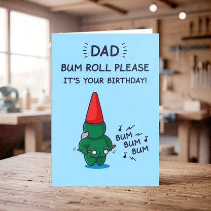 Birthday card with cartoon character and humorous text on a wooden table