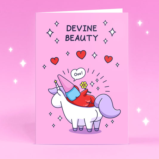 A cheeky lady gnome is laying on a unicorn with flowers, sparkles and hearts. This beautiful card has the caption 'Devine Beauty'.