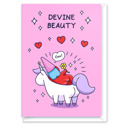 A cheeky lady gnome is laying on a unicorn with flowers, sparkles and hearts. This beautiful card has the caption 'Devine Beauty'.