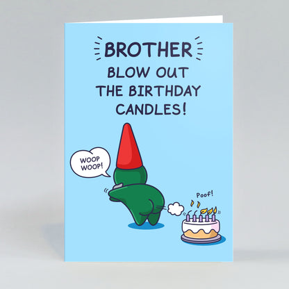 Birthday card with a cartoon character blowing out candles on a cake, text 'Brother blow out the birthday candles!', on a light blue background. A cheeky legends green gnome with a red hat is blowing out birthday candles with a fart. 