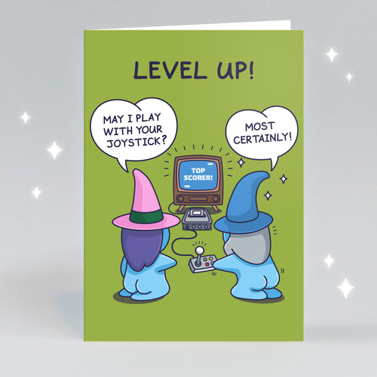 This funny computer game inspired greeting card has a cute wizard and witch couple playing a game. The Witch asks 'May I play with your Joystick' and the Wizard says 'Most certainly!' The title reads 'Level Up!' 